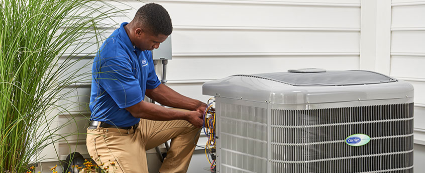 HVAC repair technician servicing an air conditioner